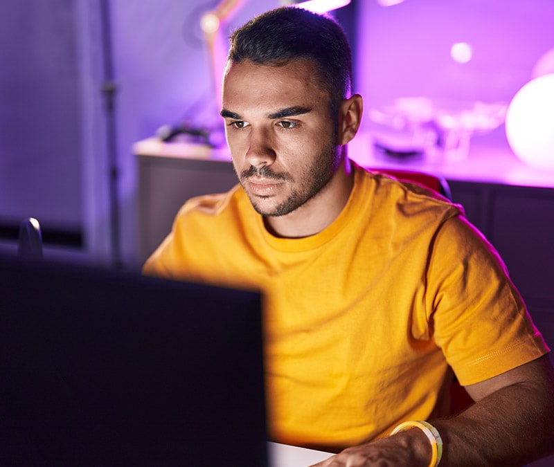 A man is sitting at a laptop, researching what the Tor Browser is and how it is used to access the dark net